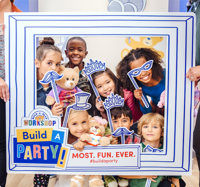 Kids posing for photo in cardboard picture frame