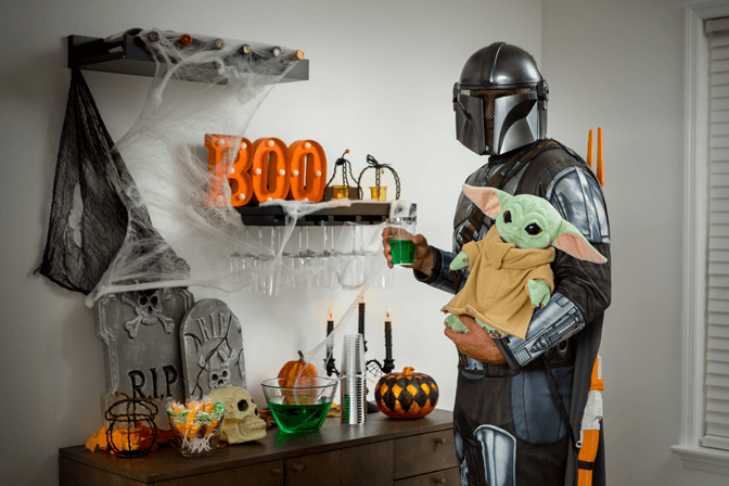 adult in the mandalorian costume with the child