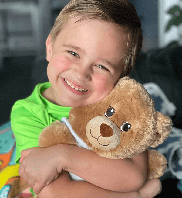 child smiling and holding bear – Build-A-Bear Foundation