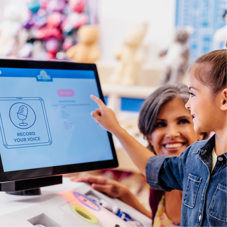 Record Your Voice people looking at computer in workshop